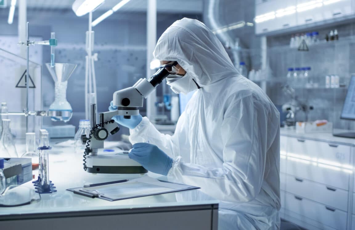 virus microscope un chercheur de laboratoire dans une combinaison examine Pétri sous Microscope ingénieur pharmaceutique