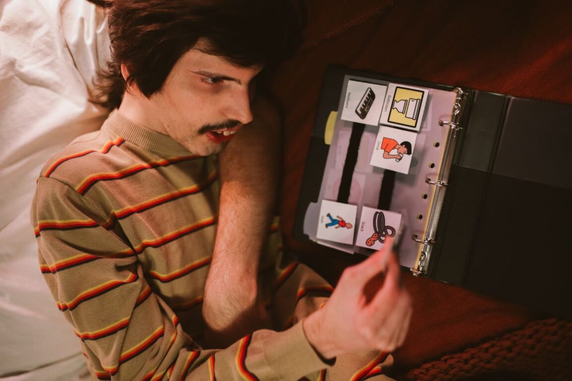 Homme autiste utilisant des cartes de communication visuelle.