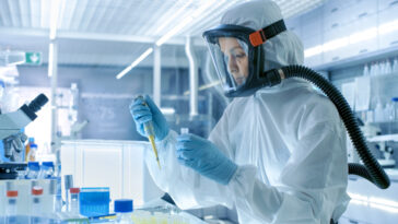 Virologie médicale recherche scientifique costume de Hazmat avec masque Micropipette. laboratoire High-Tech stérile, centre de recherche, tests chimiques ou biochimiques - Virus ou micro-organisme dangereux